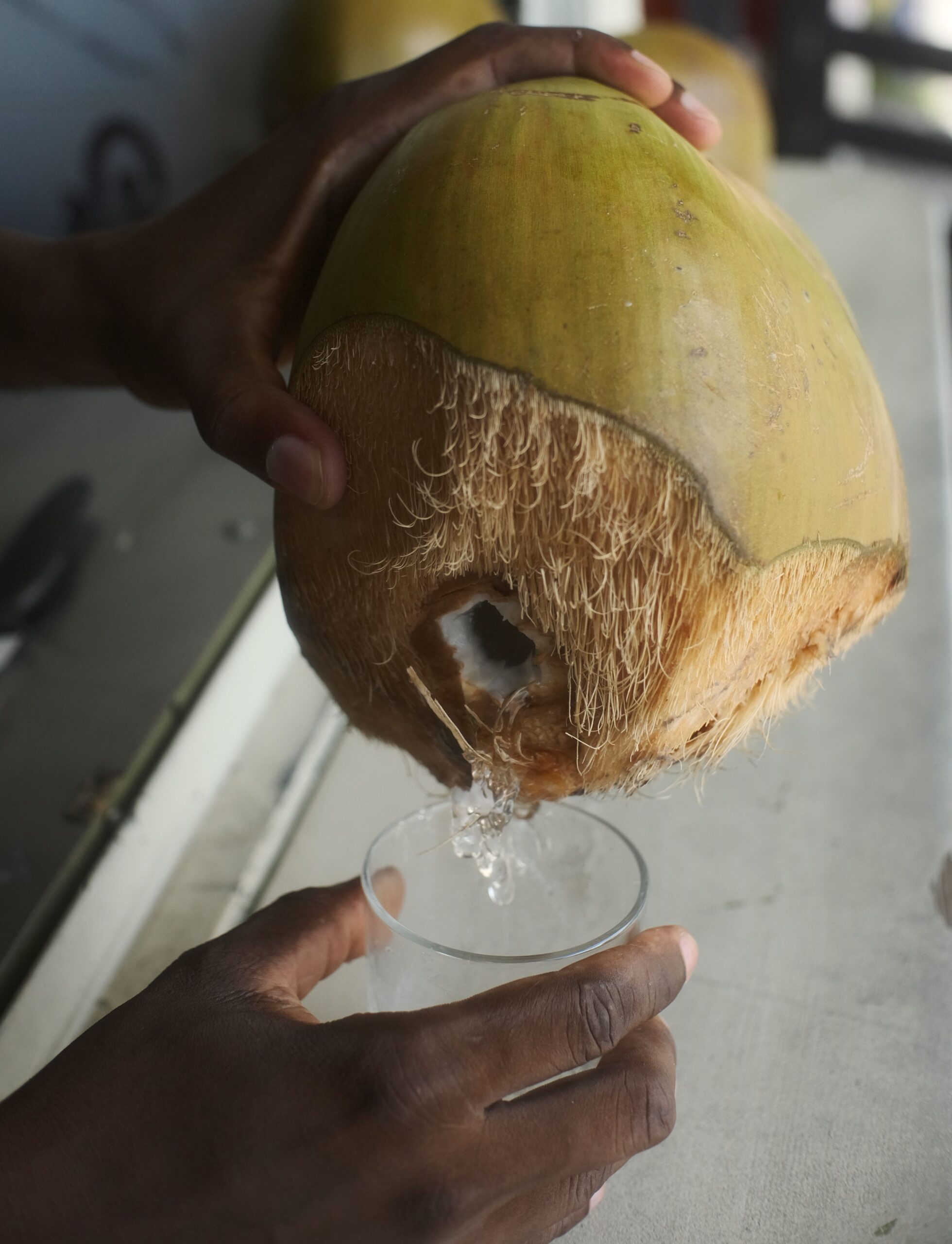 Eau de coco versée dans un verre, produit local proposé par Léoni Snack